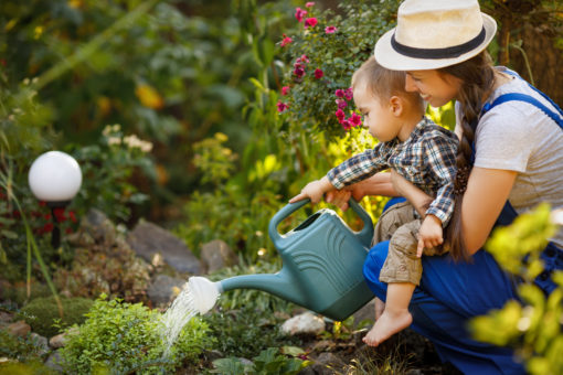 A mother and her child water their sustainable garden together.